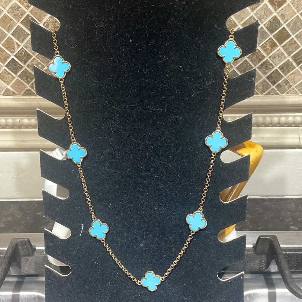 Designer inspired 36" + 3" extension. Gold plated with light blue clover shapes.